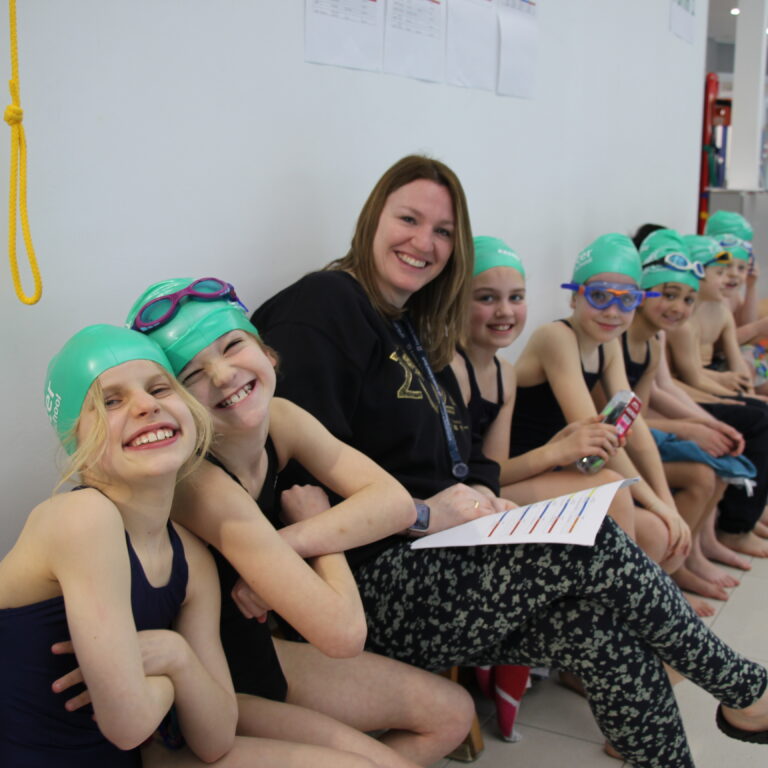 swimming students with their teacher