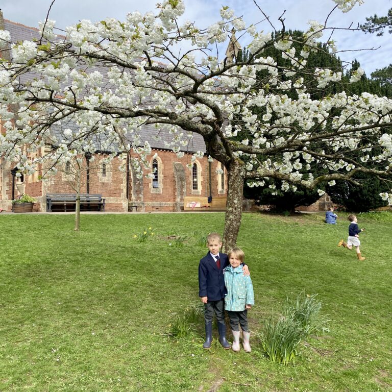 2 students stood under a tree