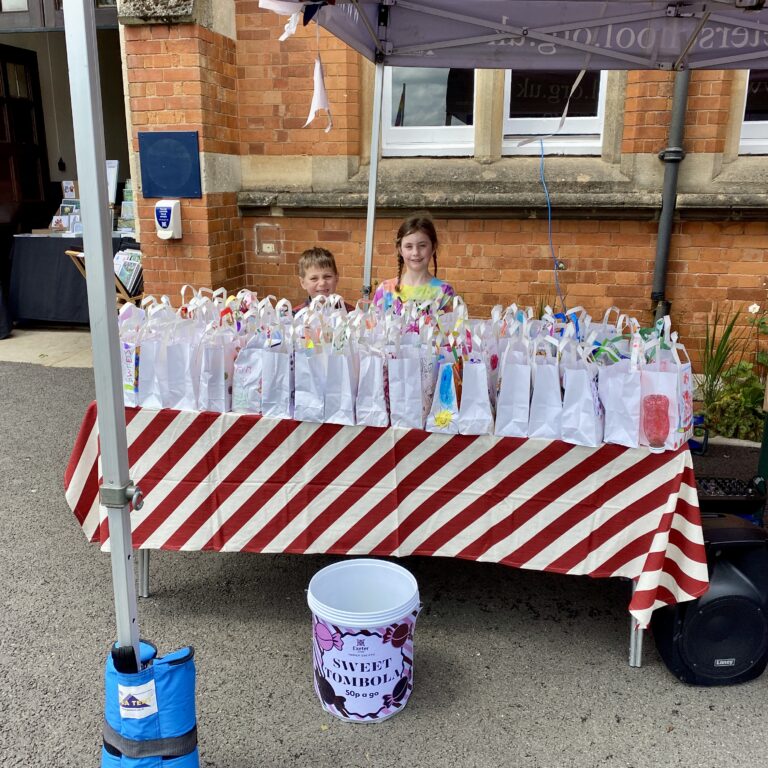 two children standing behind a tombola table